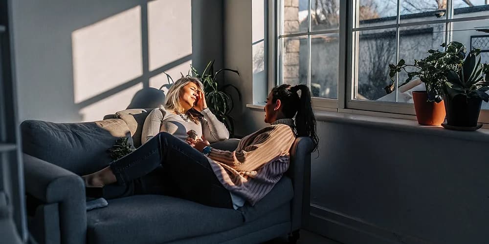 A therapist speaking warmly with a client in a bright, calm counselling office